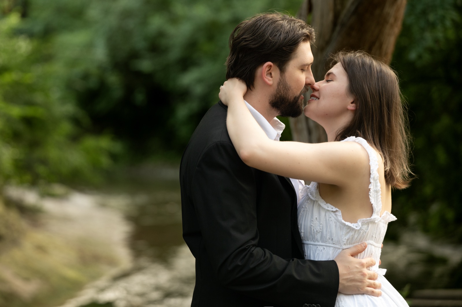 Couple kissing in a green Dallas creek setting